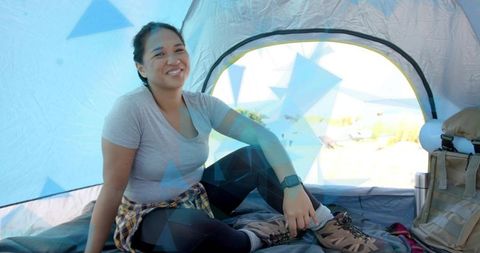 Happy Camper Relaxing in Tent with Hiking Gear