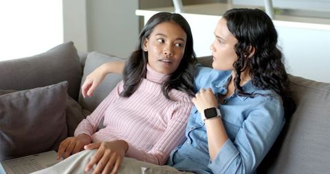 Diverse Women Connecting on Couch with Laptop and Smartwatch