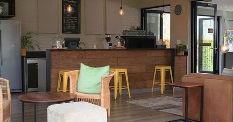 Cozy cafe interior showcasing wooden counter, espresso machine, yellow stools