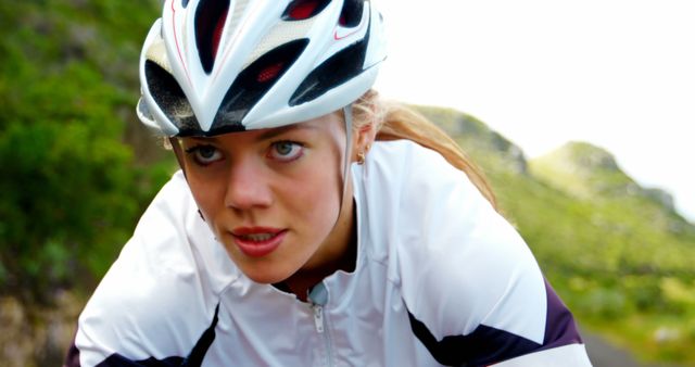 Focused Female Cyclist Wearing White Helmet Riding Outdoors - Download Free Stock Images Pikwizard.com