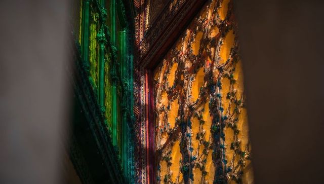 Intricate gold-toned temple panel with colored glass