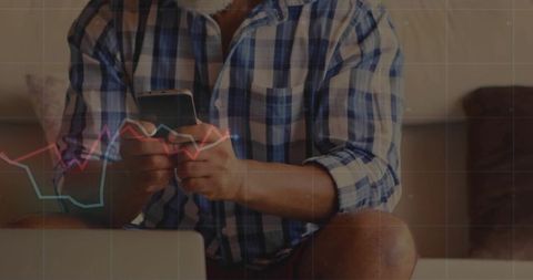 Senior Man Engaging with Financial Data at Home on Devices