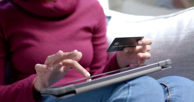 Person is using a credit card to make a purchase online via a tablet. Ideal for illustrating online shopping, digital transactions, e-commerce, and the convenience of technology in everyday life. Suitable for websites, blogs, and advertisements related to online retail, payment services, and technology products.