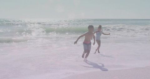 Kids Joyfully Running on Sunny Beach by Ocean Waves