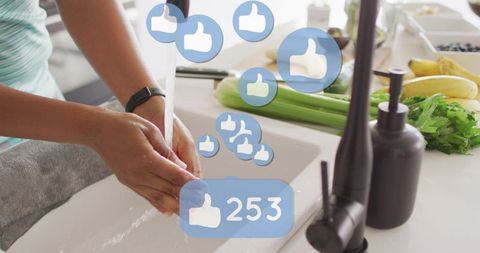 Washing hands at modern kitchen sink wearing smartwatch with social like notifications overlay