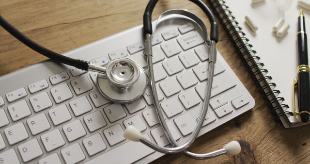 Image of close up of stethoscope with notebook and pills on wooden table. global medicine and healthcare concept.