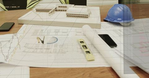 Architectural design desk with scale model, rolled plans, drafting tools and hard hat