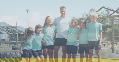 Coach and Children Enjoy Team Building on Obstacle Course