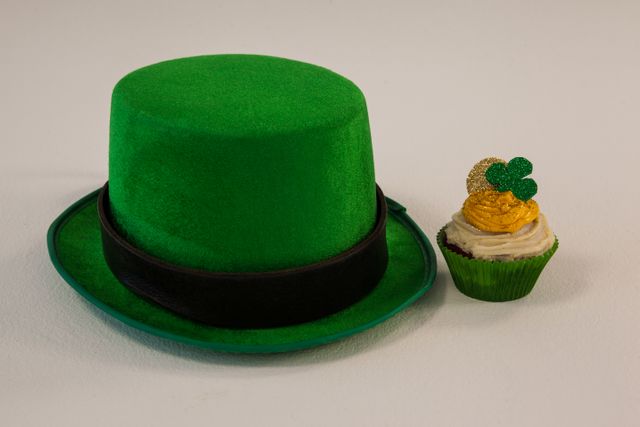 St Patricks Day leprechaun hat with shamrock on cupcake on white background