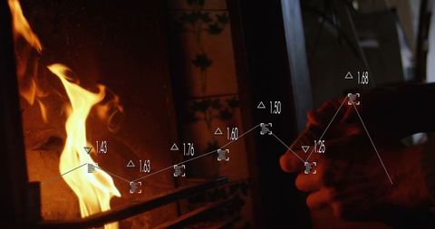 Hands Adjusting Fire Poker with Graph Overlay Near Cozy Fireplace