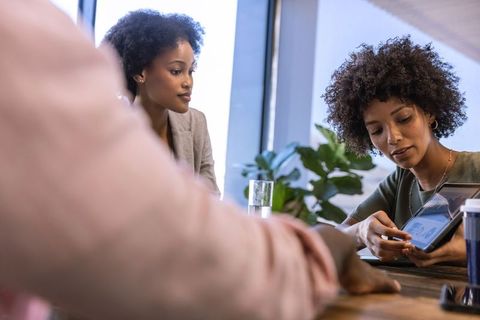 Diverse Team Discussing Data Using Tablet in Modern Office Setting