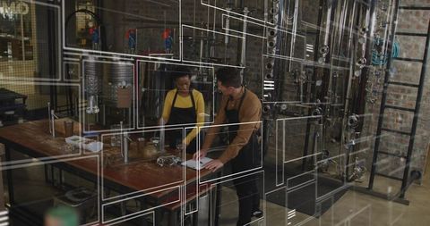 Craft Distillery Team Collaborating at Workbench, Checking Notes and Jars Near Steel Columns