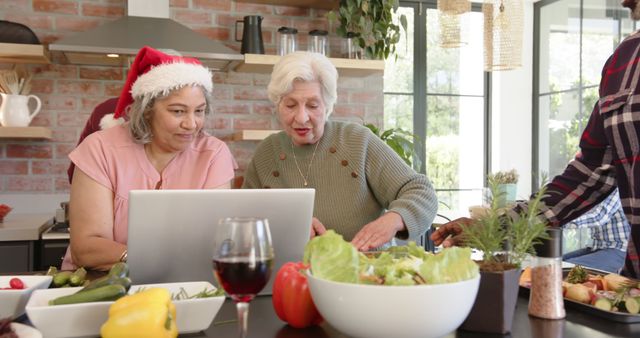 Senior Women Cooking Together and Using Laptop Wearing Santa Hat - Download Free Stock Images Pikwizard.com