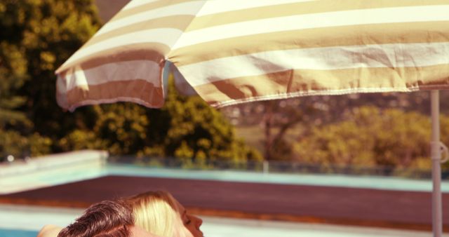 Couple Relaxing by Pool Under White and Yellow Umbrella - Download Free Stock Images Pikwizard.com