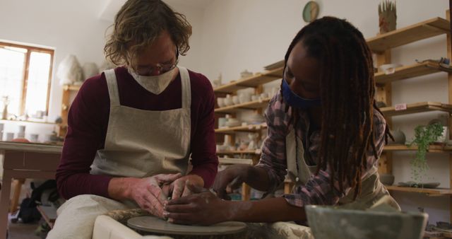 People Wearing Masks Crafting Pottery Together on Pottery Wheel - Download Free Stock Images Pikwizard.com