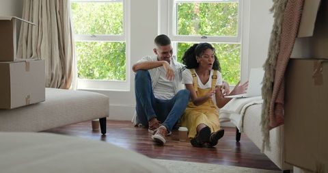 Happy Couple Video Chatting on Laptop During Move-In Day