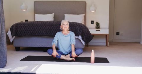 Senior Woman Meditating Peacefully in Bedroom, Promoting Calm Serenity