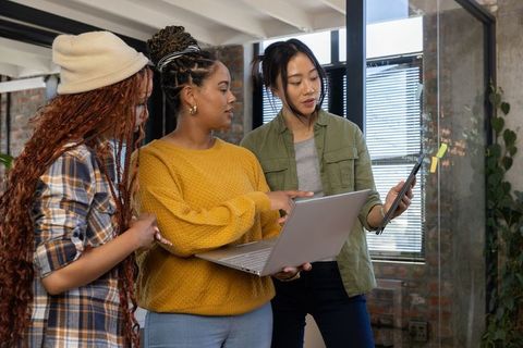 Diverse Coworkers Collaborating in Modern Office with Tech Devices