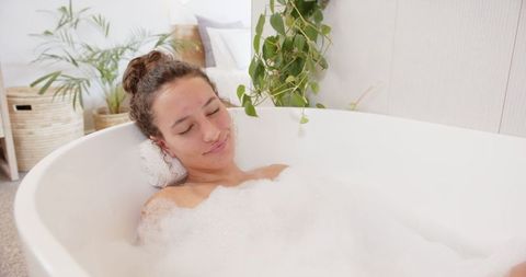 Woman Relaxing in Bubble Bath at Home Spa Setting