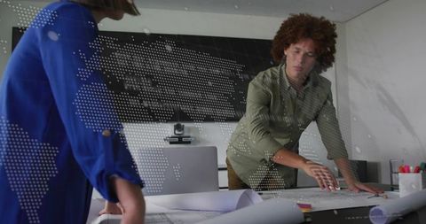 Architects reviewing blueprints at conference table with digital world map overlay