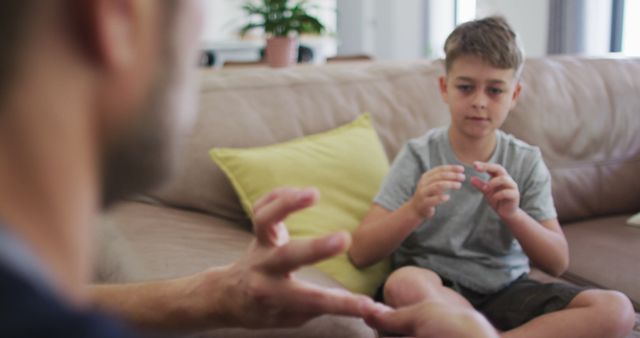 Father and Son Using Sign Language for Communication on Sofa - Download Free Stock Images Pikwizard.com