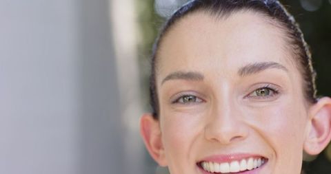 Smiling Woman Outdoors Near Green Foliage Showing Joy