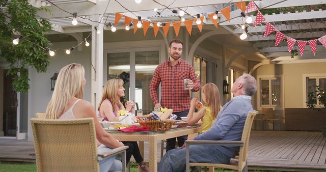 Family Enjoying Summer Evening Outdoor Dinner under String Lights - Download Free Stock Images Pikwizard.com