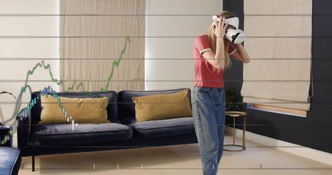 Woman wearing vr headset exploring stock trading charts in minimalist living room