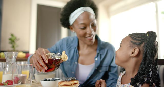 Loving Mother Pouring Syrup on Pancakes for Daughter During Breakfast - Download Free Stock Images Pikwizard.com