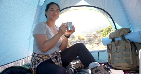 Woman Relaxing on Camping Trip with Cup Drink Enjoying Scenic Nature