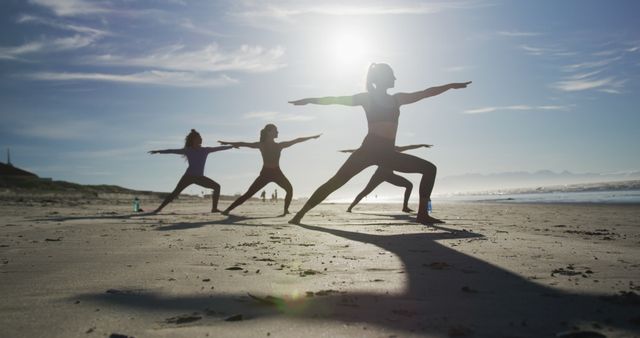 Group of diverse female friends practicing yoga at the beach. healthy active lifestyle, outdoor fitness and wellbeing.