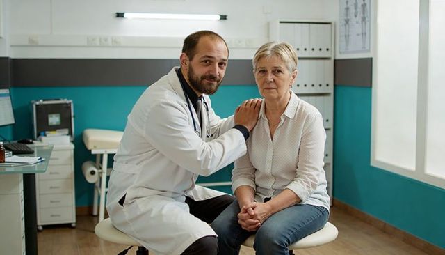 Doctor comforting senior woman during medical consultation, compassionate patient care