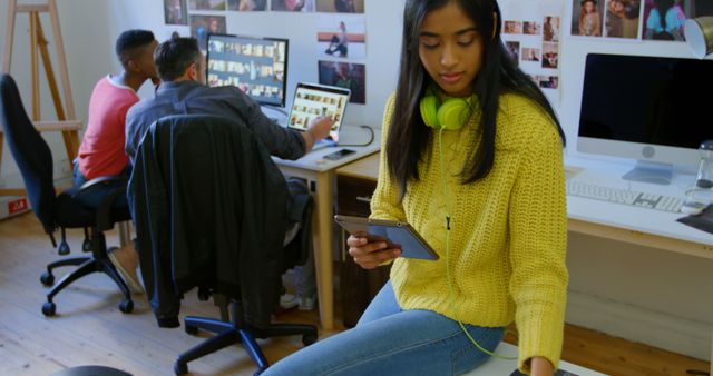 Young Woman Taking Break with Tablet and Headphones in Creative Office - Download Free Stock Images Pikwizard.com