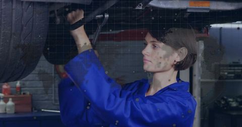 Female mechanic skillfully adjusting wheel in auto repair shop