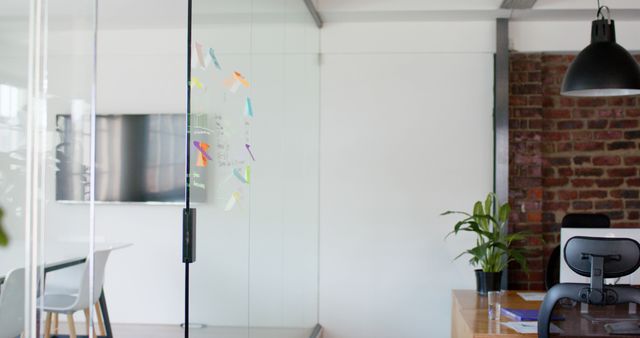 Empty modern office with computers and glass wall with memo notes. Business, work and technology.