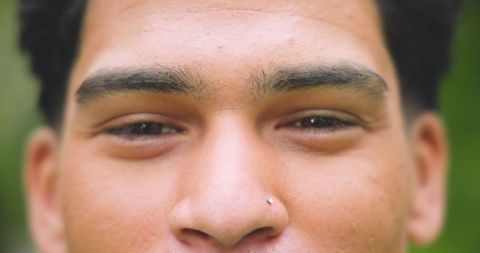 Close-up of Man with Nose Stud Against Nature Backdrop
