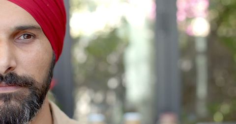Portrait of man wearing red turban outdoors with intense expression