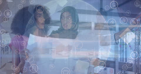 Diverse Businesswomen Collaborating Over Digital Icon Overlay