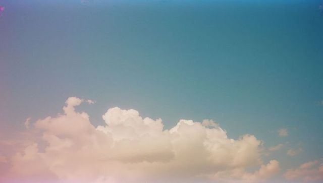 Pastel cumulus clouds in turquoise lavender sky