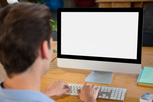 Rear view of graphic designer using desktop pc 