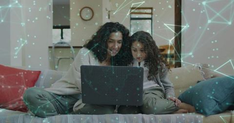 Mother and daughter learning together on sofa with laptop and digital network overlay