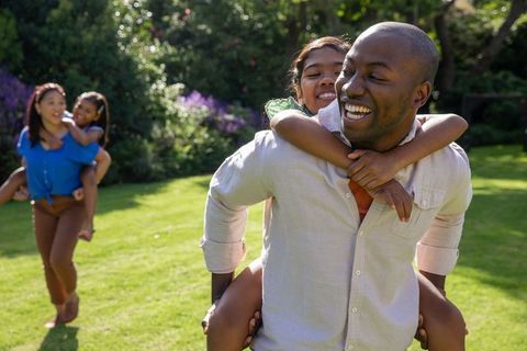 Happy Family Playing Together in Sunlit Garden