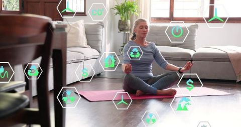 Senior woman meditating on pink yoga mat in sunlit living room with eco icons overlay