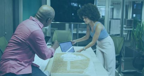 Professionals Collaborating on Architectural Model in Modern Office