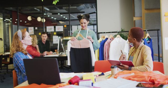 Happy diverse business people discussing work with clothes at office. Work at a modern office.