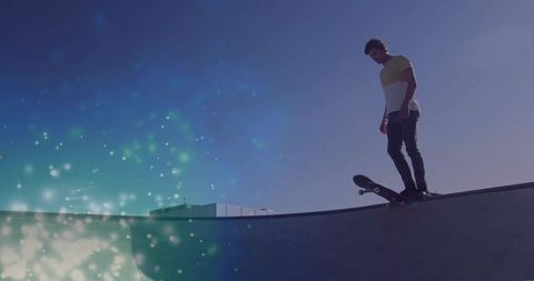 Balancing skateboarder on ramp against luminous background