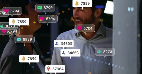 Business colleagues chatting amid social media alerts at night