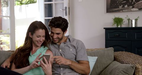 Cheerful Couple Enjoying Memories on Smartphone