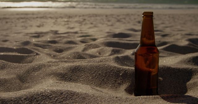 Empty Beer Bottle on Sandy Beach at Sunset - Download Free Stock Images Pikwizard.com
