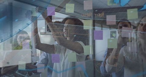 Team collaborating on glass board with innovative ideas